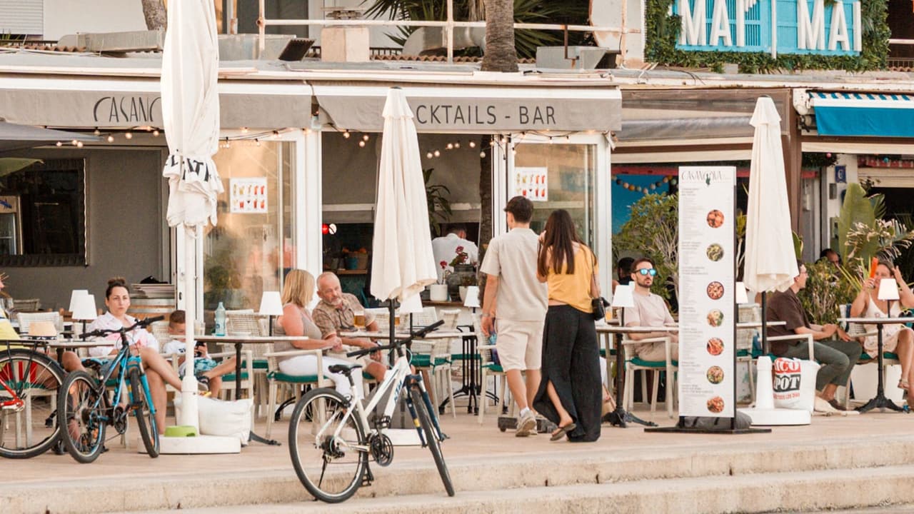Clientes cenando en la terraza de Casanova frente al mar de Cala Estancia